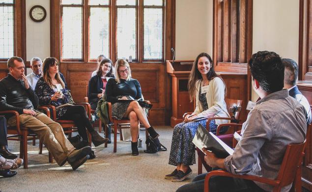 Katherine Clifton ’15 sits in the center of a group of about eight people.