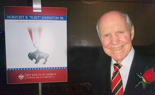 Norfleet Johnson ’56 next to a sign from the Boy Scouts of America about his Silver Buffalo award.