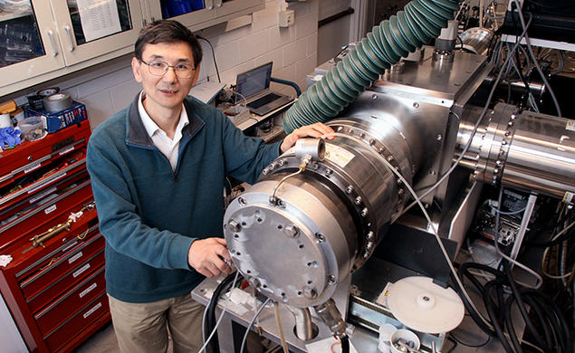 Yiguang Ju and some sort of machine with a red tool chest in the background.