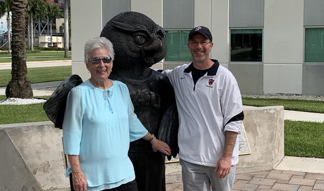 Two people stand with a statue.