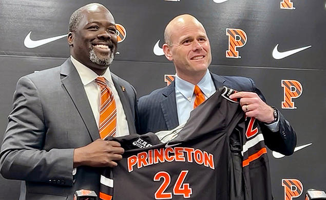 Athletics director John Mack ’00, left, and men’s hockey coach Ben Syer, right hold a Princeton hockey jersey at an April 26 press conference. 