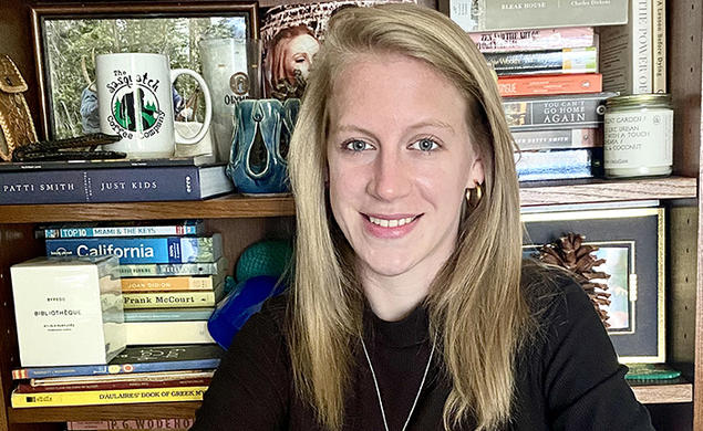 This is a photo of Jessica Welsh ’14 with a bookcase in the background.