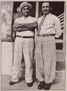 Two men in an old, sepia-toned newspaper photo.