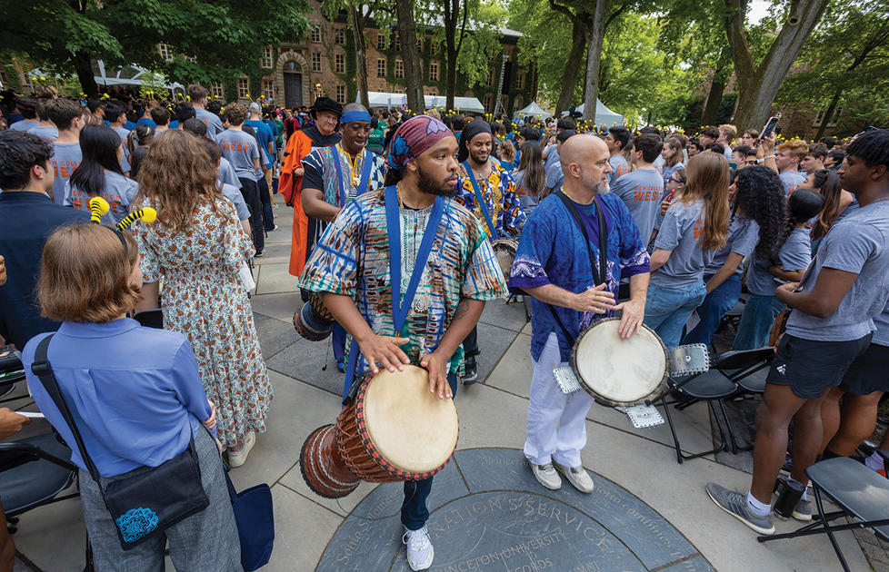 Students play drums while marching in the Pre-rade.