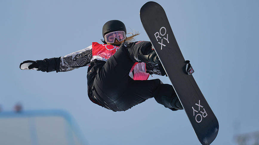 Chloe Kim flying up high on her snowboard.