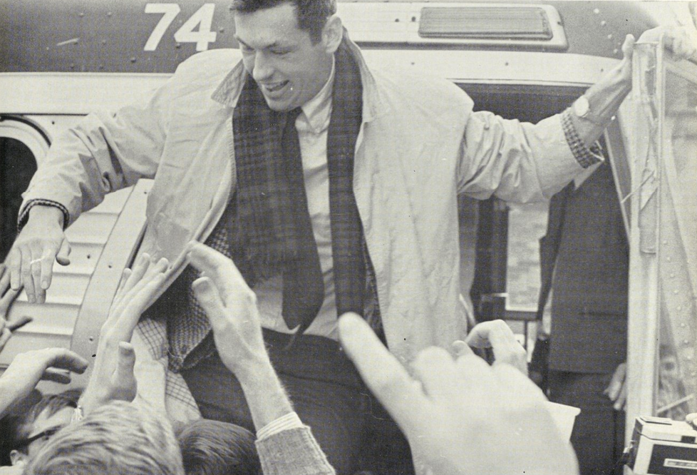 Bill Bradley greets students as he exits from a bus