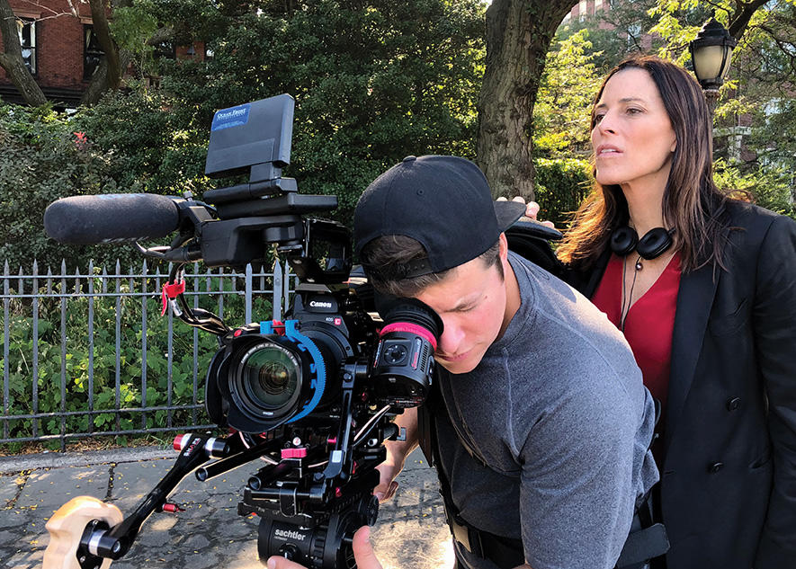 Cecilia Peck standing behind a camera directing a documentary