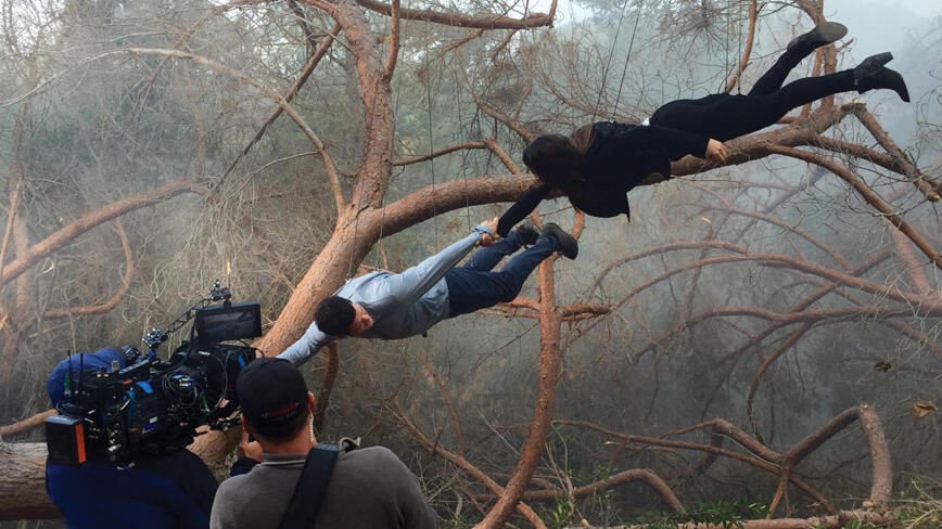 Michlle De Mond hangs on to another actor while being blown away by a tornado on the set of Scorpion