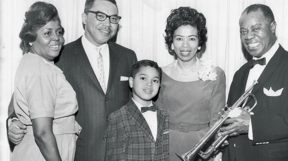 A younger Jones is shown with his parents, left, meeting the legendary musician Louis Armstrong and his wife, Lucille Wilson.
