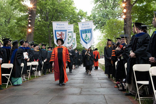 Students carry the banners of the residential colleges during the procession.