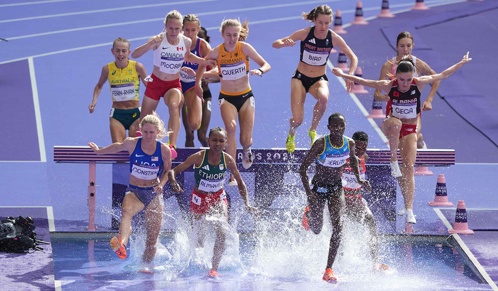 Lizzie Bird ’17, top, clears the hurdle on the water jump in the women’s 3,000-meter steeplechase. 