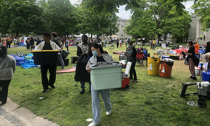 Protesters carry plastic tubs on Cannon Green.