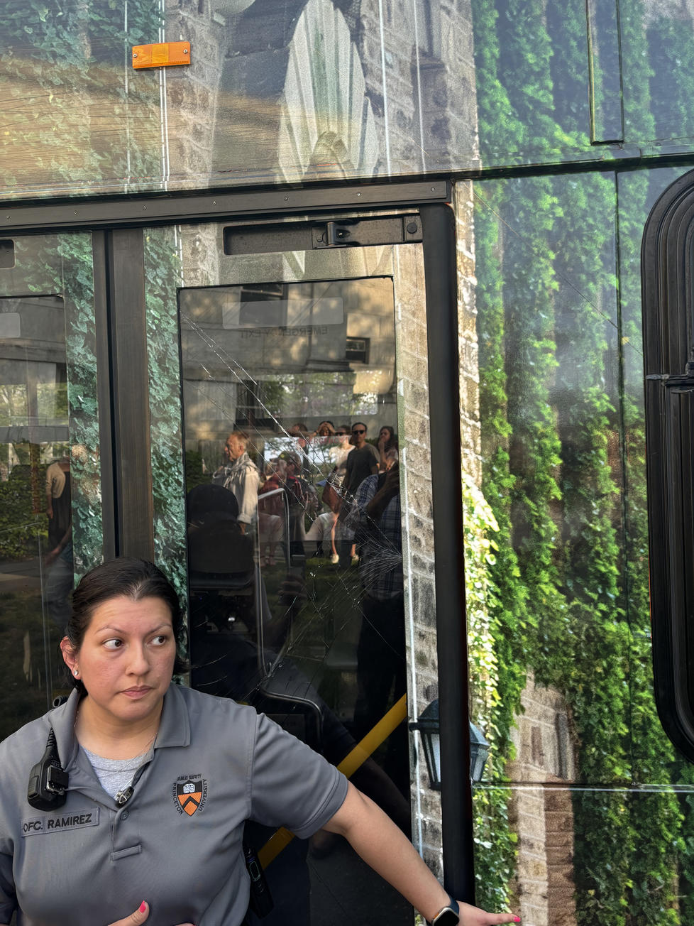 The cracks protesters put in a bus passenger door are visible behind this Public Safety officer.  