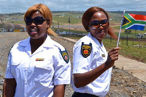 South Africans take photos and catch glimpses of Nelson Mandela’s funeral from the periphery of the ceremony in Qunu.