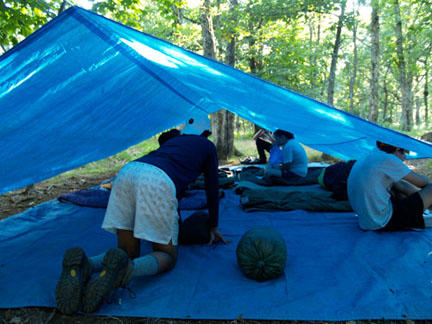 Setting up camp under a tarp for the night.
