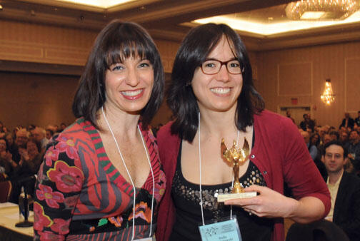 Fifth-place finisher Stella Daily Zawistowski ’00, holding her trophy, stands with puzzle co-announcer Ophira Eisenberg of NPR