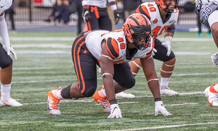 Defensive lineman Uche Ndukwe ’23 crouching to get ready to run.