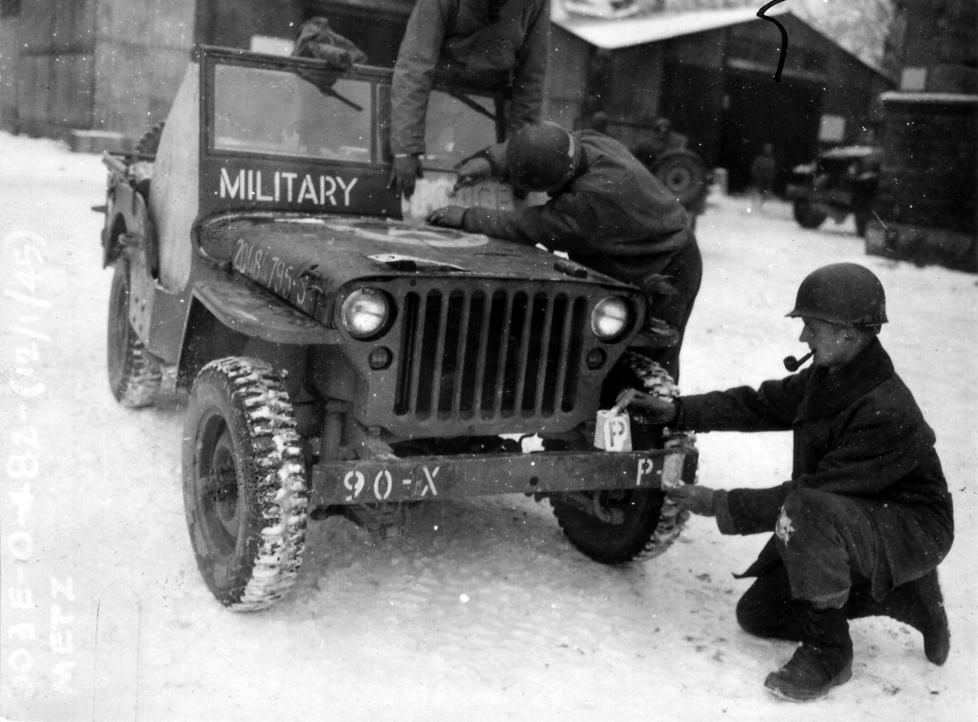 The Ghost Army also took care to make its markings consistent with the unit it was impersonating. In Metz, France, soldiers stencil 90th Division markings on the bumper of a jeep.