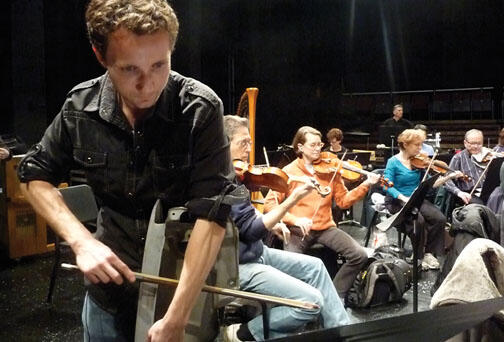 LIVE.NB_CarParts.jpg Sean Friar GS bows a car fender during a rehearsal of his “Clunker Concerto.”