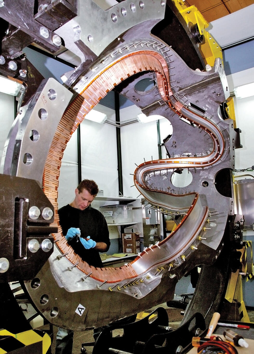 PPPL technician Doug Voorhees works on one of the stellerator’s 18 coils. The project is being shut down.