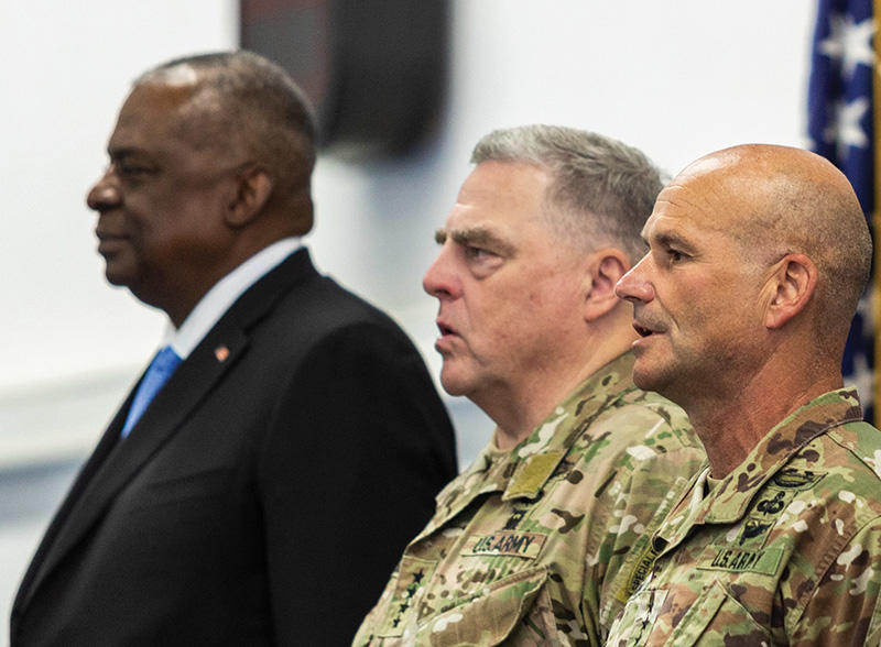 Gen. Mark Milley, center, with fellow Princetonian Gen. Christopher Cavoli ’87, right, and Defense Secretary Lloyd Austin stand at attention while an armed forces medley is played in Stuttgart, Germany, in July 2022. 