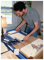 Alexander Bick GS, founder of the independent publishing house Crumpled Press, prepares a book cover for binding.