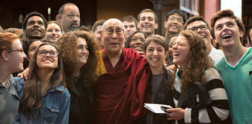 Students look up for a photo with the Dalai Lama in Chancellor Green.