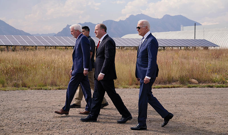 Jared Polis ’96, center, walks with President Joe Biden 