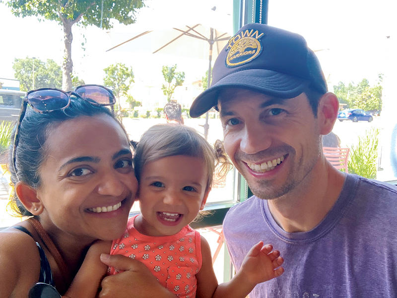 Miles Patrie *16 with his wife, Aparna, and their 18-month-old, Maya.