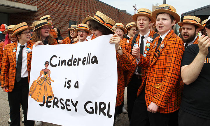 Wearing orange plaid and straw hats, the Princeton band holds a sign that reads, "Cinderella is a Jersey Girl."