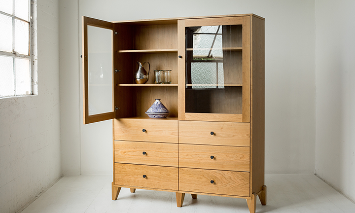 A curio cabinet made of cherry wood.