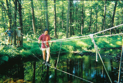 Traversing a three-rope bridge at Princeton Blairstown Center.