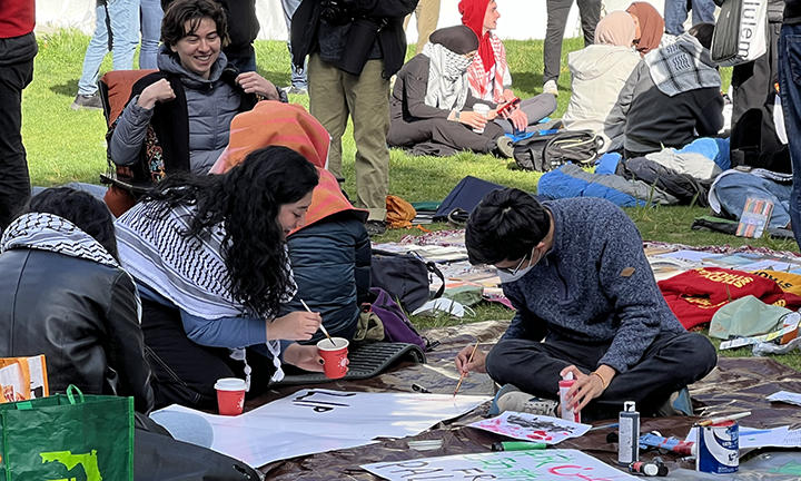 Students paint a banner on the ground.