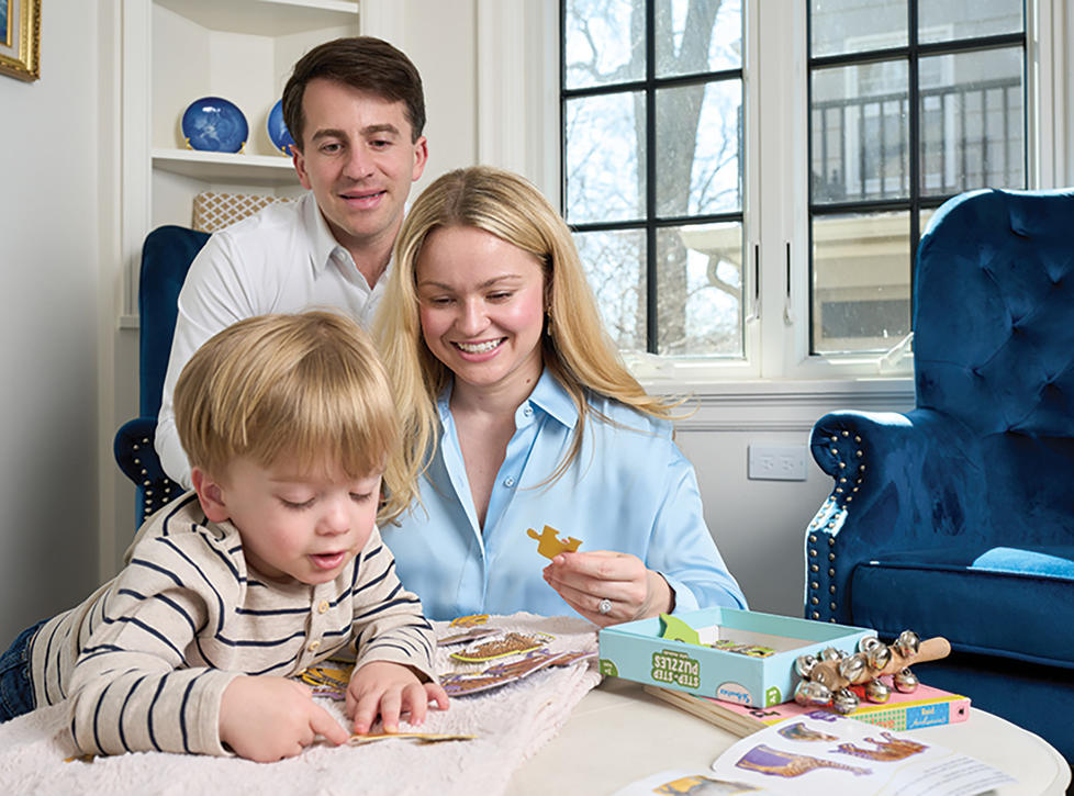 Brittany Sanders Robb ’13 at home with her husband, Andrew, and their son.