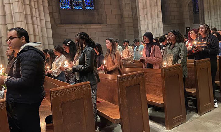 Attendees hold candles during vigil in the Chapel on Monday.