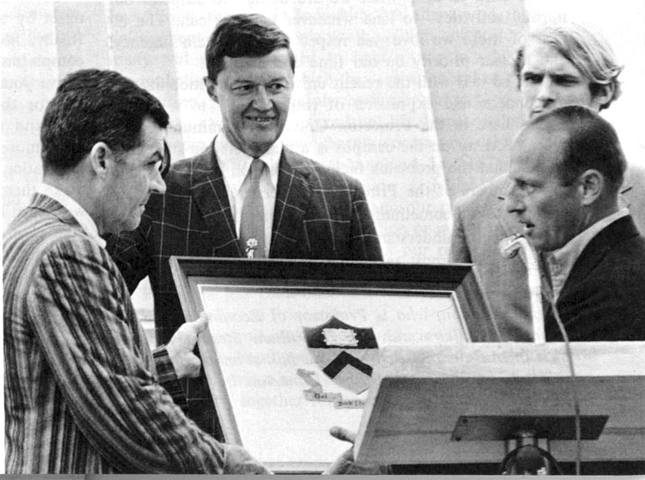 Astronaut Charles Conrad ’53 presents President Robert Goheen ’40 *48 with the Princeton flag he took to he moon. Looking on is D. Bruce Merrifield ’42, chairman of the Alumni Council.  