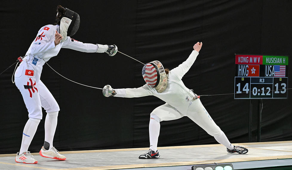 Fencer Hadley Husisian, right, lunges toward opponent Man Wai Vivian Kong