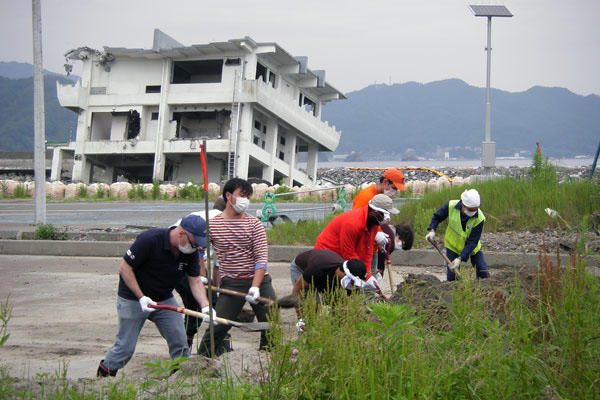 Participants in a Global Seminar studying issues facing post-tsunami Japan work to clear an area near a site in Kamaishi where dozens of homes were washed away.