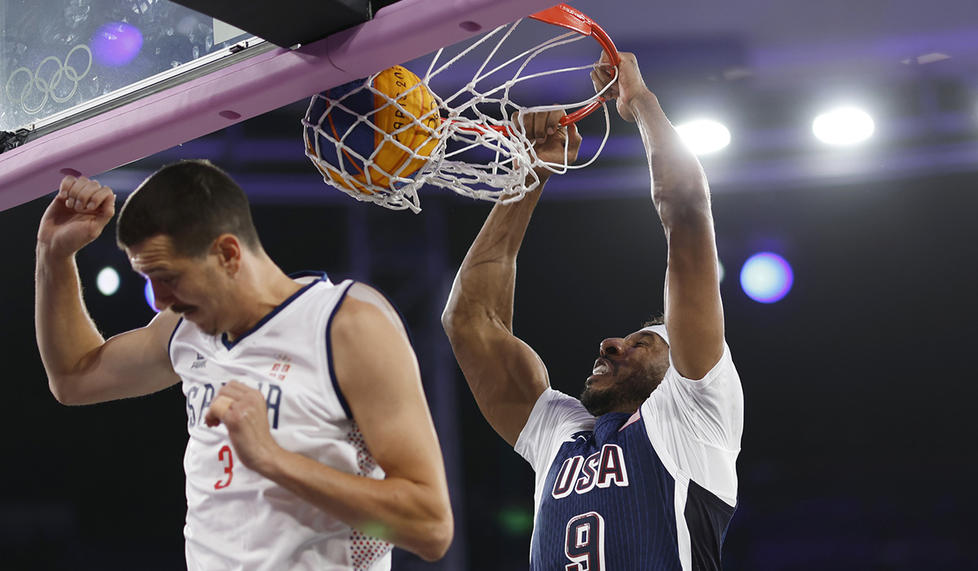 Kareem Maddox dunks over Serbia’s Strahinja Stojacic in a July 30 3x3 basketball game. The U.S. improved to 2-4 in pool play with wins over France and China Aug. 2. 