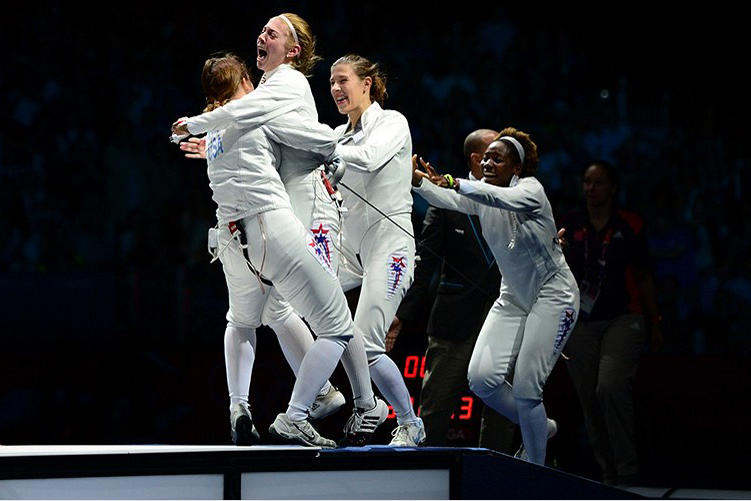 Aug. 4: Susie Scanlan '14, second from left, and Maya Lawrence '02, right, joined the celebration after Courtney Hurley, left, scored a touch in overtime to lead the United States over Russia in the women's team epee bronze-medal match. 