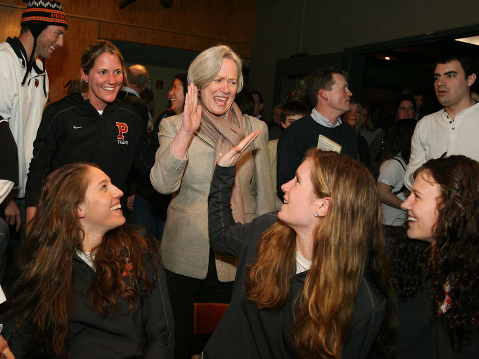 President Tilghman high-fives guard Blake Dietrick '15 as the Tigers await their destination at a March 18 selection-show party in Princeton. Princeton earned a No. 9 seed, facing No. 8 Florida State in the opening round.