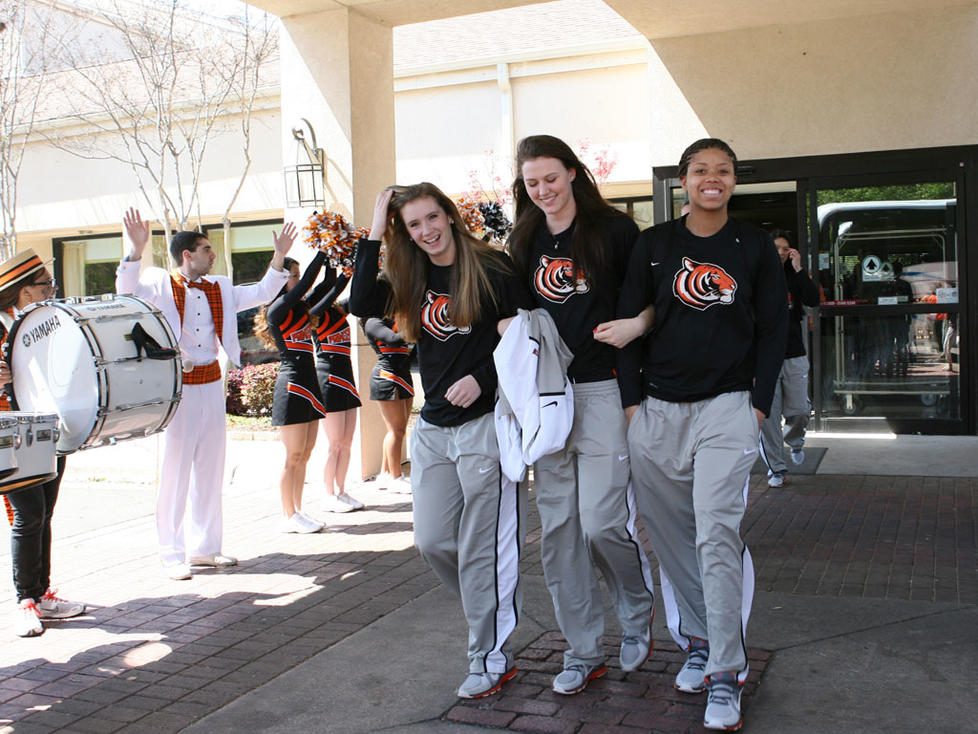 From left, Blake Dietrick '15, Jess Shivers '15, and Mariah Smith '15 get a rousing sendoff from the team hotel, thanks to the Princeton cheerleaders and band.